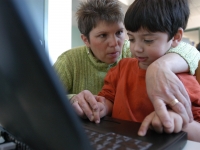 Samuel works on a laptop with physical therapists Colleen Sullivan in her office on March 31, 2005.  (Dan Habib/Concord Monitor)